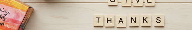 Three SOX Coffee boxes on a wooden surface with 'GIVE THANKS' spelled out using letter tiles.